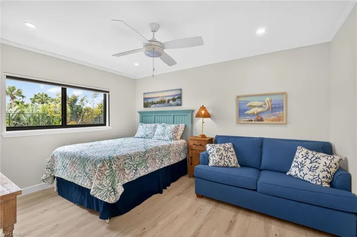 Bedroom with light wood finished floors, ornamental molding, recessed lighting, and a ceiling fan