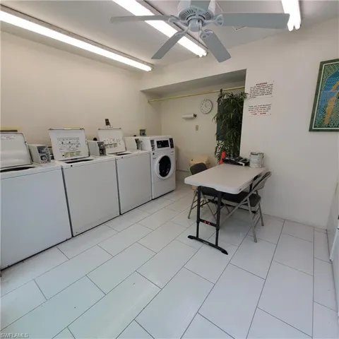 Communal laundry room with independent washer and dryer, a ceiling fan, and light tile patterned floors