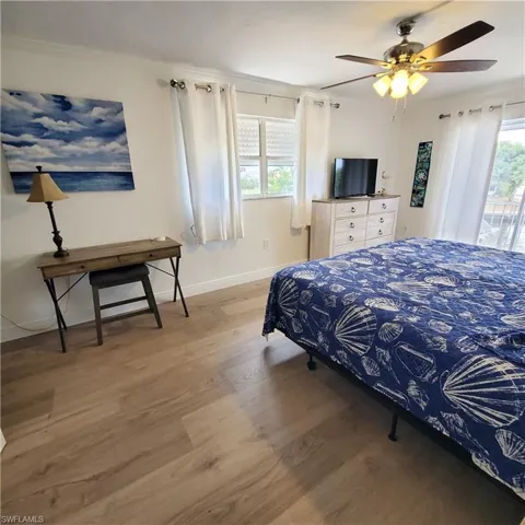 Bedroom featuring  wood-style flooring, a ceiling fan, and ornamental molding