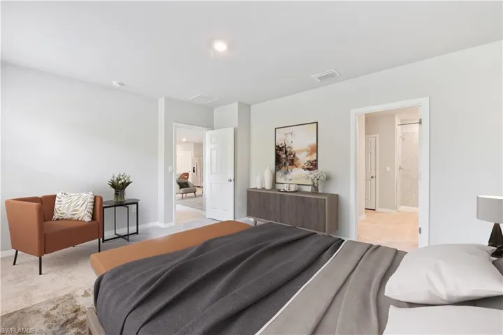 This home is virtually staged. Bedroom featuring light carpet and connected bathroom