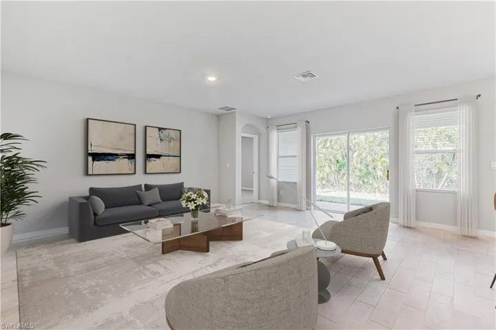 This home is virtually staged. Living room with arched walkways and recessed lighting