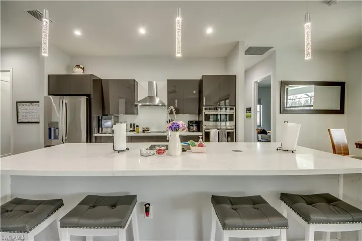 Kitchen featuring modern cabinets, a large island, appliances with stainless steel finishes, a kitchen breakfast bar, and recessed lighting