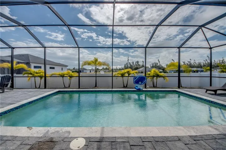 Outdoor pool with a sunroom and a lanai