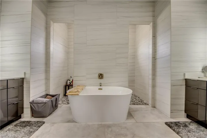 Bathroom with vanity, tile walls, and a freestanding bath