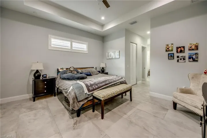 Bedroom featuring a tray ceiling, a ceiling fan, recessed lighting, and a closet