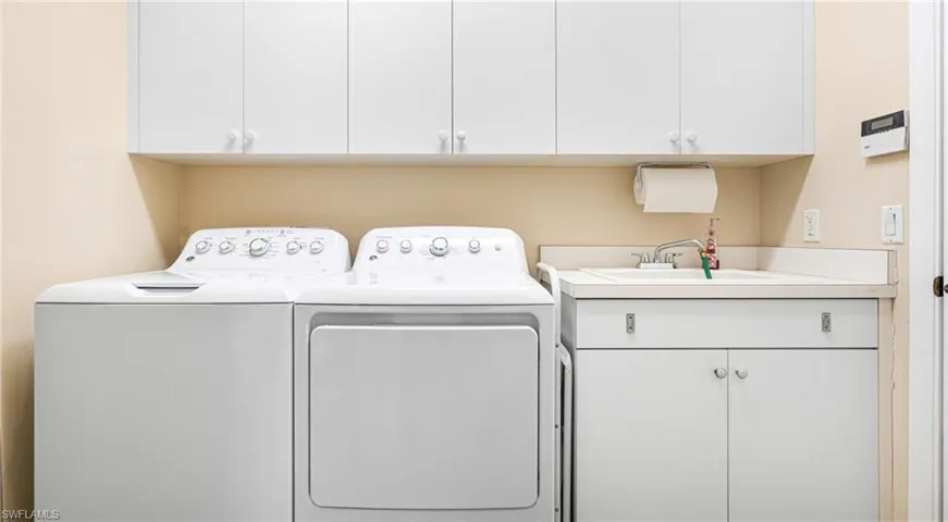 laundry with cabinets leads to the garage