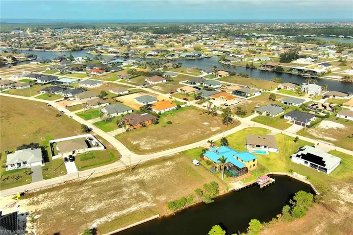 Aerial overview of property's location featuring a nearby body of water and nearby suburban area