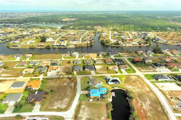 Aerial view of property and surrounding area with a large body of water and nearby suburban area