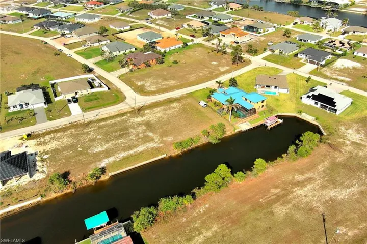 Aerial view of property's location with a nearby body of water and nearby suburban area