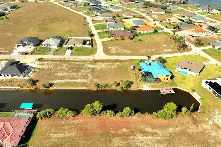 Aerial perspective of suburban area featuring a nearby body of water