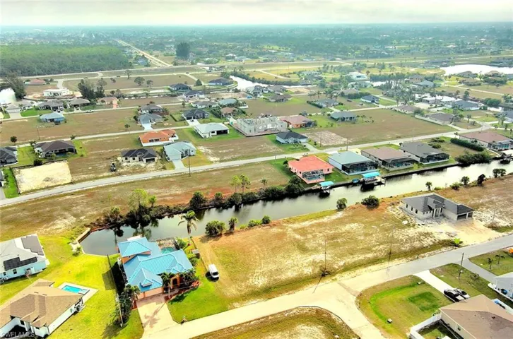 Aerial perspective of suburban area featuring a nearby body of water