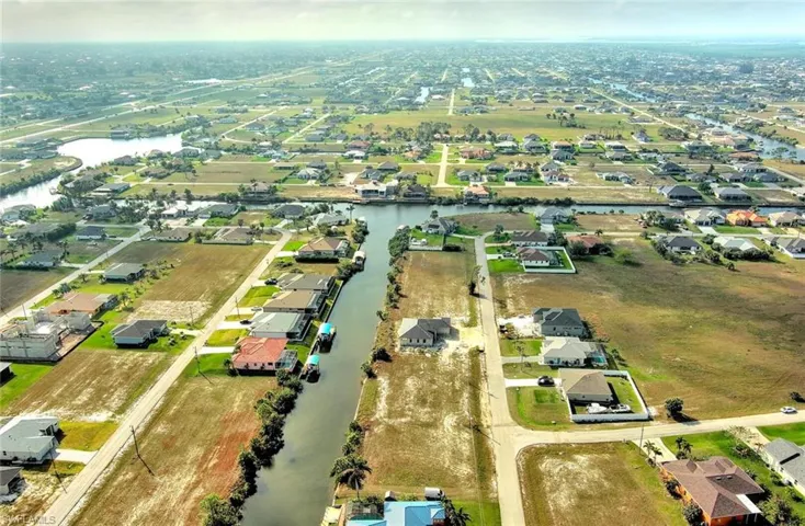 Aerial view of property's location with a nearby body of water and nearby suburban area