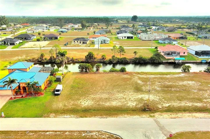 Aerial perspective of suburban area featuring a nearby body of water