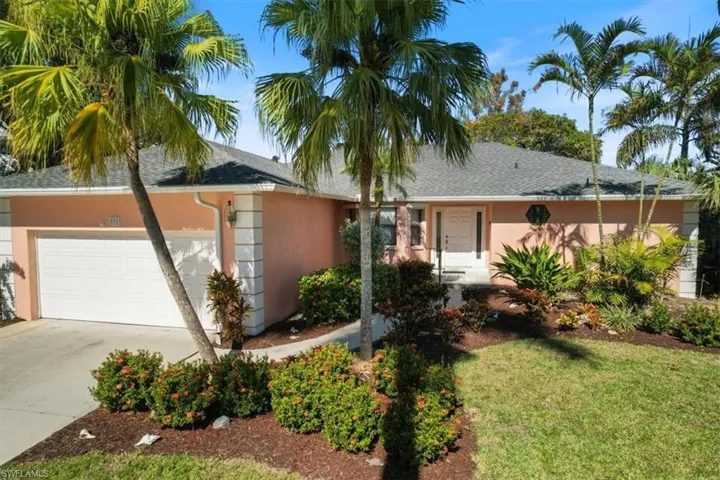 Single story home featuring a garage and a front lawn
