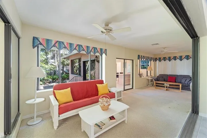 Carpeted living room with ceiling fan