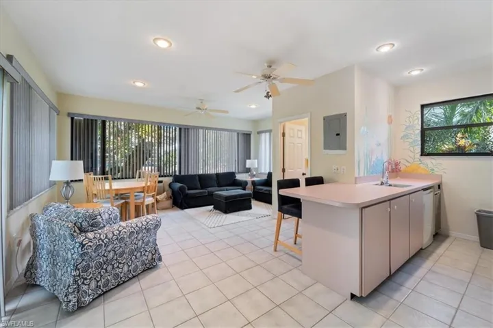 Kitchen with kitchen peninsula, electric panel, ceiling fan, and sink