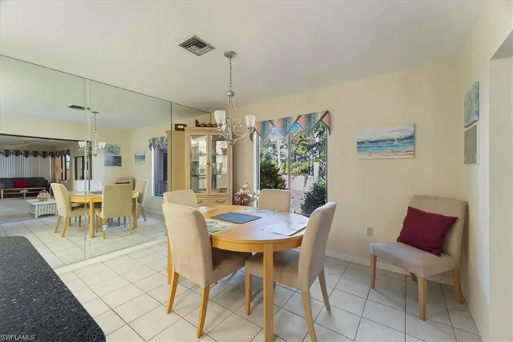 Tiled dining room with a chandelier