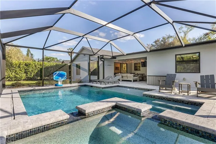 View of swimming pool featuring a lanai, a patio area, and an outdoor living space