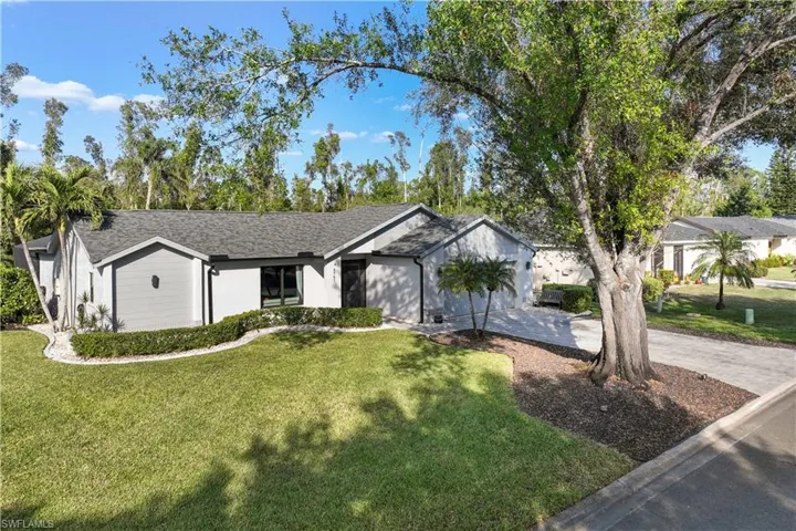 Ranch-style home with a garage and a front lawn