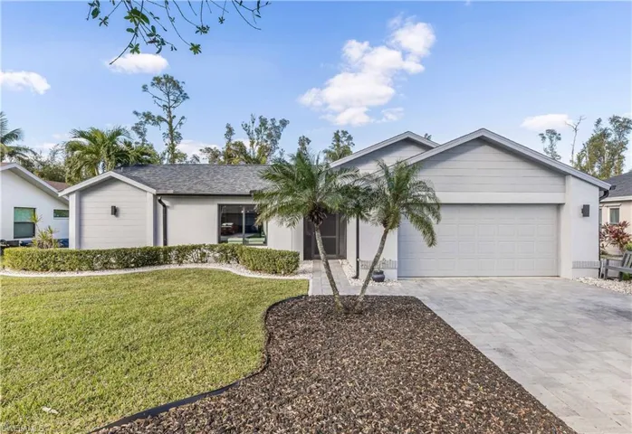 Ranch-style house featuring a garage and a front yard