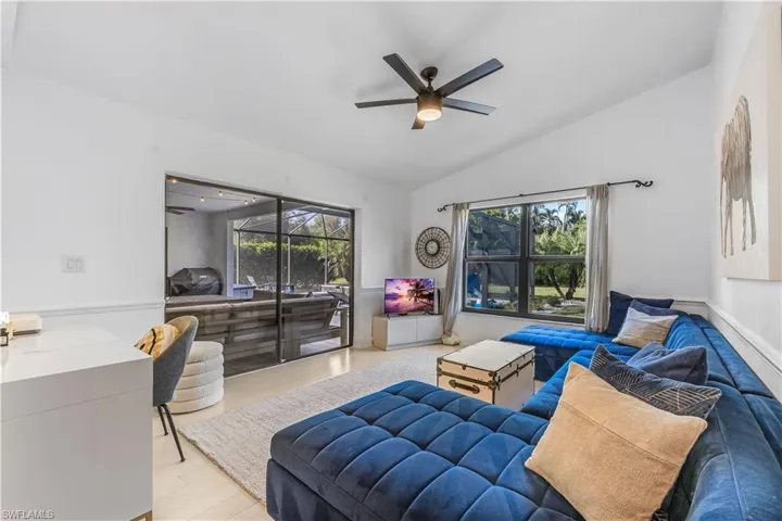 Living room with ceiling fan, light hardwood / wood-style flooring, and vaulted ceiling