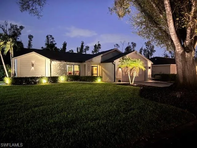 Ranch-style home featuring a garage and a yard
