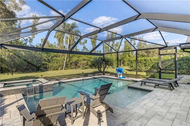 View of swimming pool with a lanai, a patio area, and an in ground hot tub
