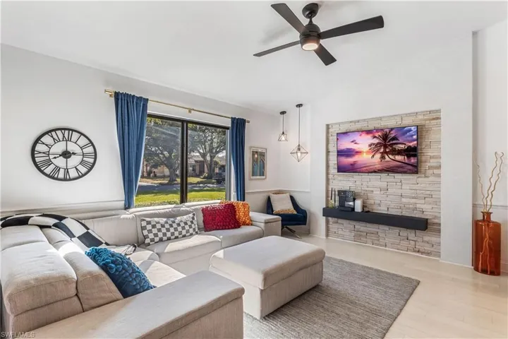 Living room featuring light hardwood / wood-style floors, ceiling fan, and lofted ceiling