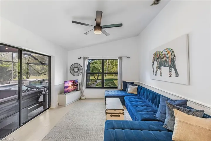Living room featuring ceiling fan, light hardwood / wood-style floors, and lofted ceiling