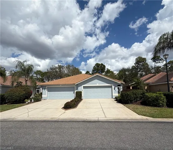 Ranch-style house featuring an attached garage, driveway, and stucco siding