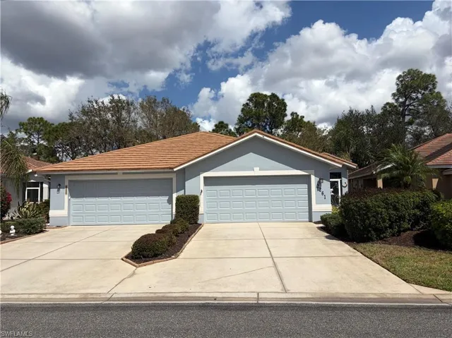 Ranch-style house with stucco siding, concrete driveway, a tile roof, and an attached garage