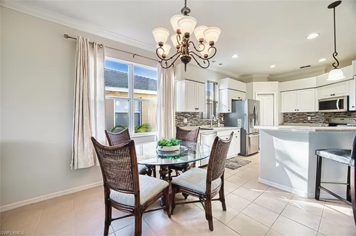 Dining room featuring crown molding, light tile patterned flooring, a chandelier, and recessed lighting