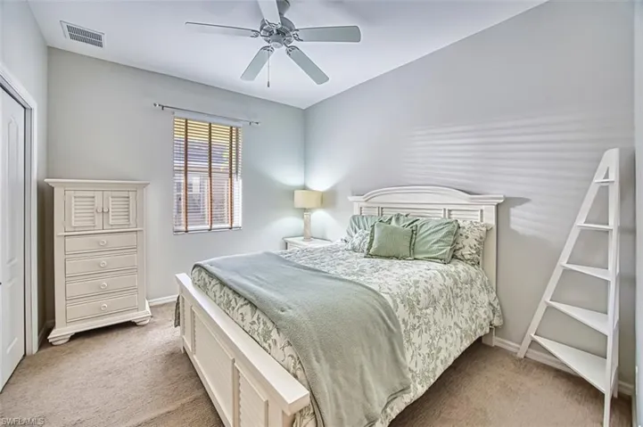 Bedroom featuring light colored carpet, a ceiling fan, and a closet