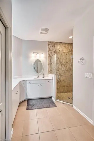 Full bathroom featuring vanity, a shower stall, light tile patterned flooring, and recessed lighting