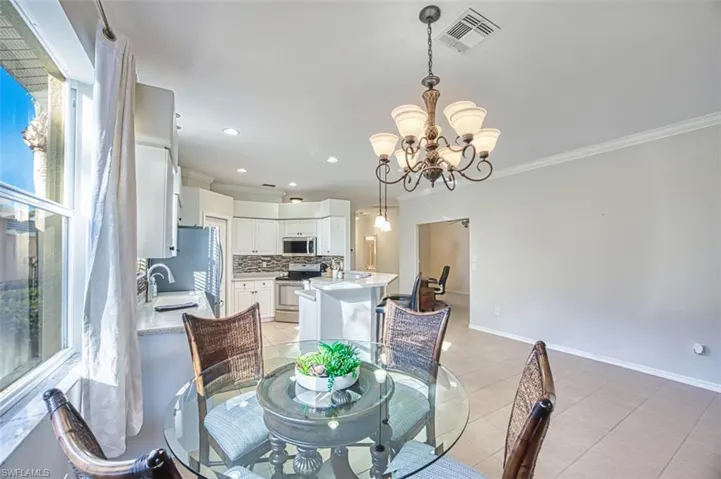 Dining area featuring crown molding, light tile patterned floors, a chandelier, and recessed lighting