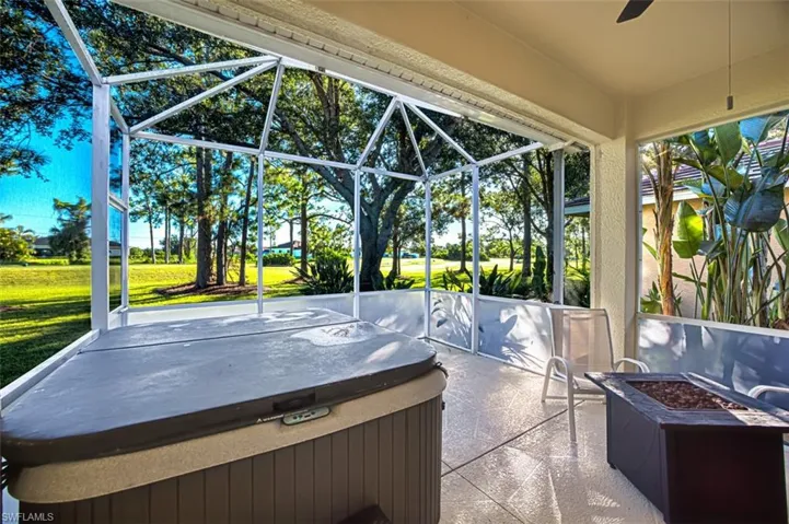 Sunroom featuring an outdoor fire pit, a patio area, a jacuzzi, and ceiling fan