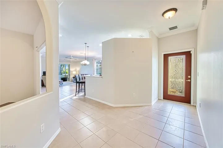 Foyer entrance featuring light tile patterned floors and ornamental molding