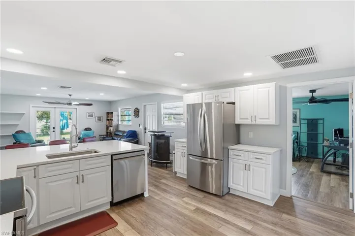 Kitchen featuring a ceiling fan, open floor plan, stainless steel appliances, and recessed lighting