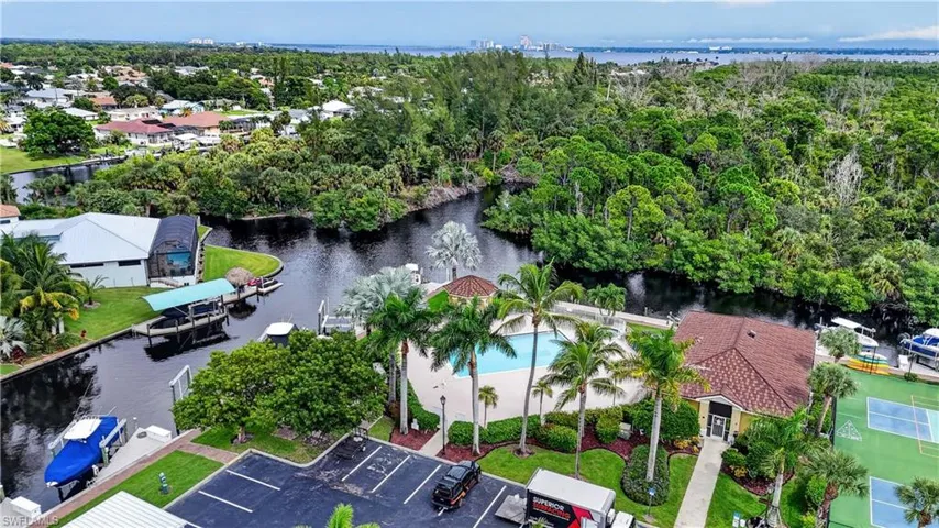 Expansive canal system, lush tropical landscaping, recreational pool area, tennis courts, and a community building with covered patio