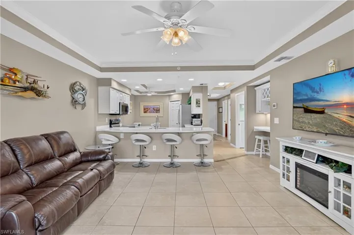 Open-concept living area with tile flooring and crown molding