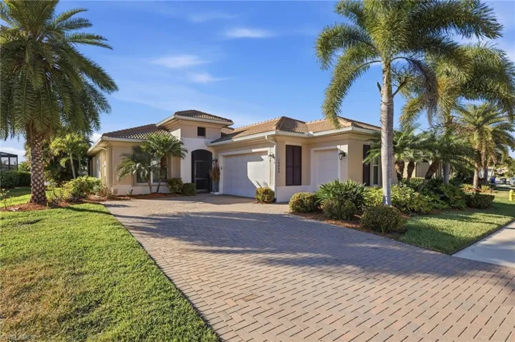 Mediterranean / spanish home with decorative driveway, an attached garage, stucco siding, and a front lawn