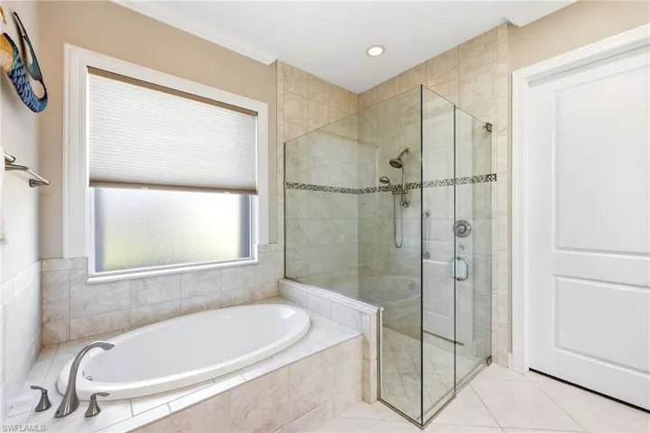 Full bathroom with a stall shower, a garden tub, tile patterned flooring, and crown molding