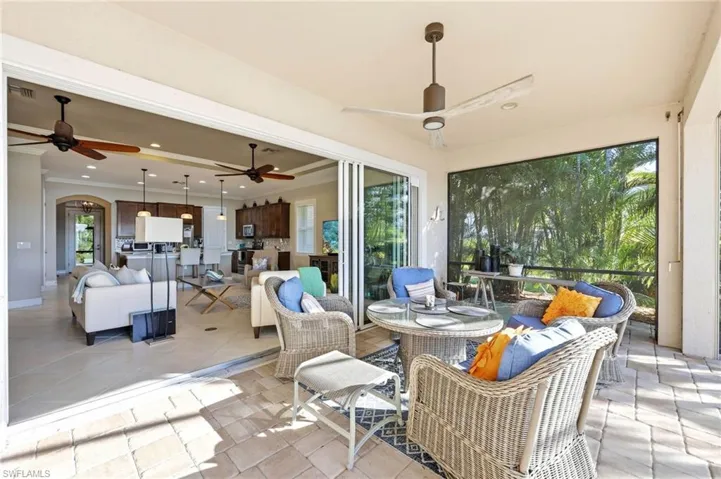 Sunroom / solarium with an outdoor hangout area, arched walkways, ceiling fan, and a patio