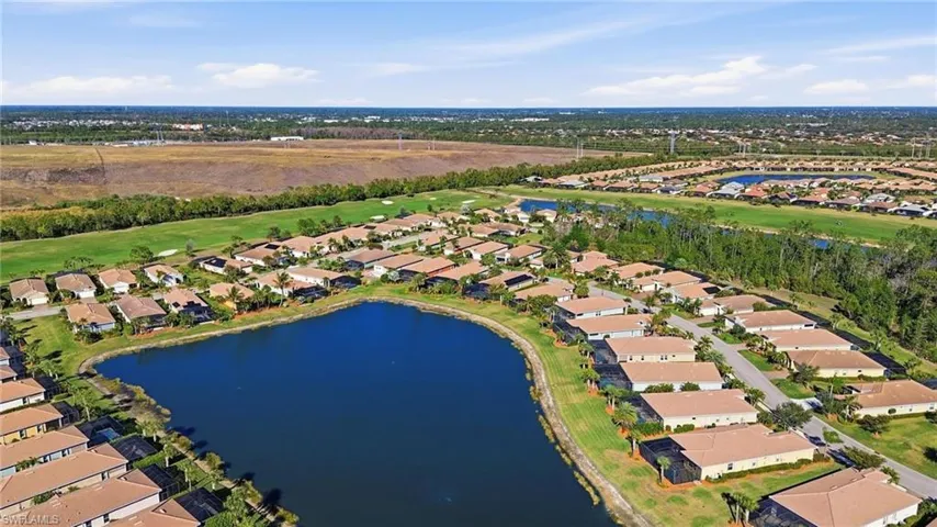 Aerial view of property and surrounding area with nearby suburban area and a large body of water
