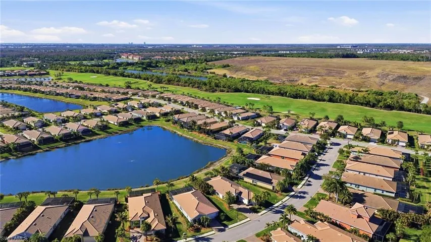 Aerial view of residential area with a large body of water and a golf course