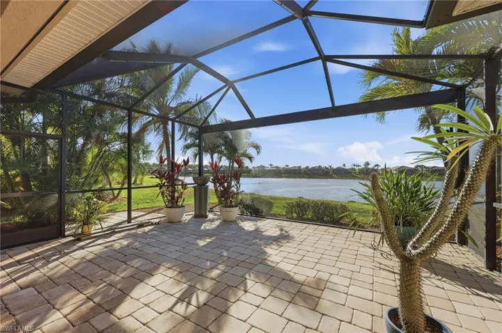 View of patio with a lanai, a sunroom, and a water view