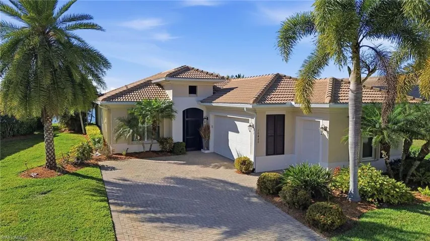 Mediterranean / spanish house with stucco siding, a front yard, decorative driveway, and a garage