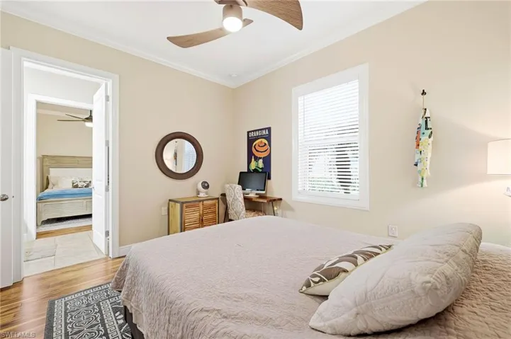 Bedroom featuring ornamental molding, a ceiling fan, and light wood-type flooring