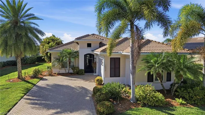 Mediterranean / spanish-style home with decorative driveway, stucco siding, a tiled roof, and a front yard