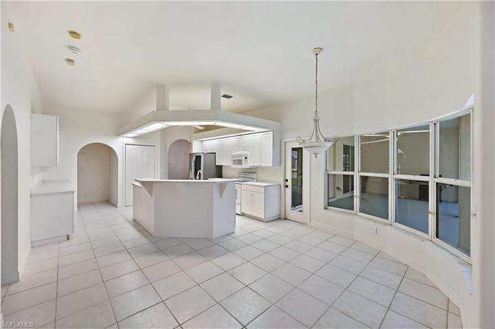 The kitchen and breakfast dining area overlook the lanai and pool